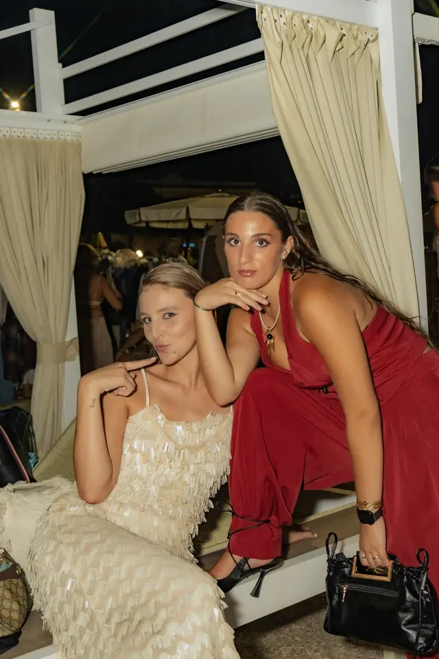 Due ragazze in abito paillettes e tuta rossa dopo la sfilata